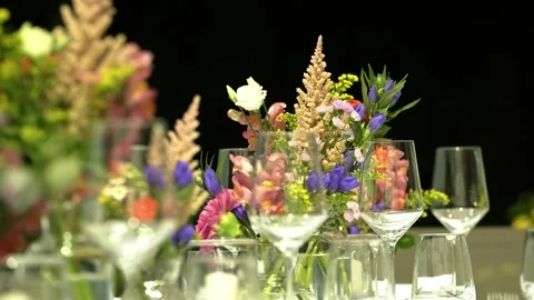 Table arrangement with empty wine-glasses and flowers in natural garden colors Video stock 248379225