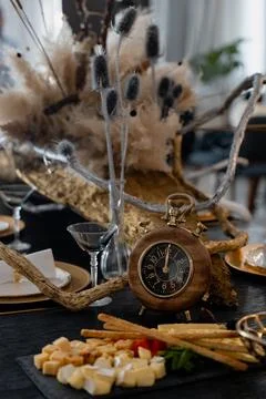 Table arrangemet with a round clock and snacks appetizers. Wooden theme - r.. Photos