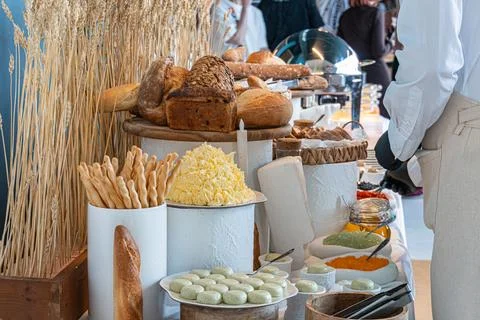 Table with assorted breads, pastries, and cheeses Buffet setup with condime.. Foto stock