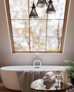 A table with bath essentials set in a luxurious contemporary bathroom with .. Stock Illustration