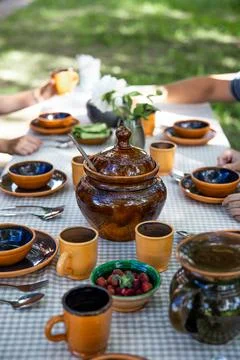 A table with beautiful earthenware in the yard on a sunny summer day Stock Photos