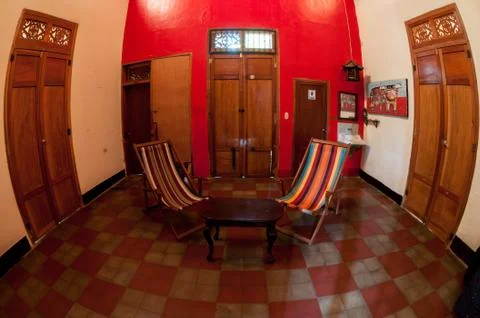 Table between two deck chair  inside old colonial house with wood ceiling and Stock Photos