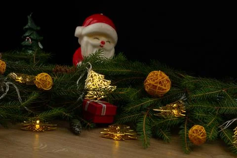 On the table on a black background are branches of a Christmas tree decorated Stock Photos