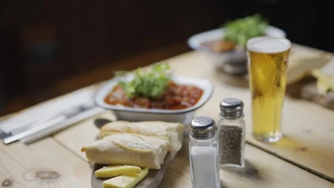 A table with a bowl of soup, bread, and a glass of beer Video stock 296056521