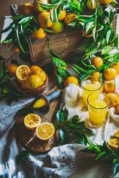 Table with box of fresh orange with orange tree branch and fresh orange juice Stock Photos