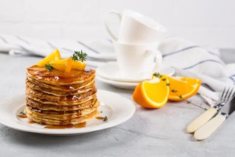 Table of breakfast . Pancakes with orange and sprinkled maple syrup, orange Fotos de archivo