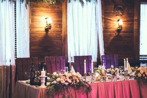 Table for bride and groom with decor, flowers, candles and dishes Stock Photos