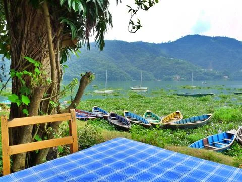 Table with bright blue table cloth beside Fewa lake, Pokhara, Nepal Stock Photos