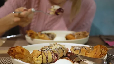 At a table with a brown-beige pattern on the tablecloth, there are two large Stock Footage 147855113