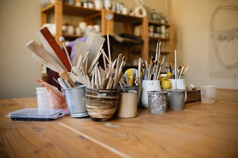 Table with brushes and tools in an art workshop. Background. Stock Photos