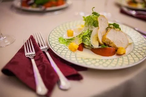 On the table Caesar salad with cutlery Stock Photos