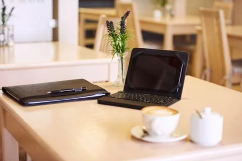Table in a cafe with an electronic tablet and coffee Foto stock