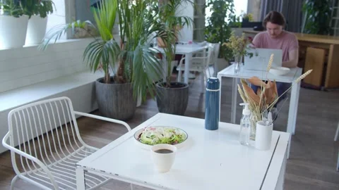 Table in cafe, on table is Cup of coffee and plate of salad, in background man Stock Footage 132217992