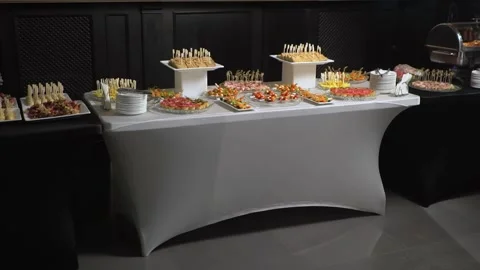 A table with catering is covered with a black cloth. Stock Footage 159366855