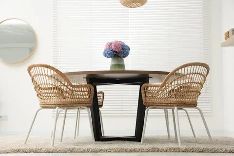 Table, chairs and vase of hydrangea flowers in dining room, low angle view... Stock Photos