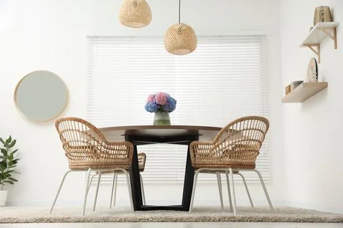 Table, chairs and vase of hydrangea flowers in dining room, low angle view... Stock Photos