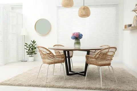 Table, chairs and vase of hydrangea flowers in dining room. Stylish interior Stock Photos