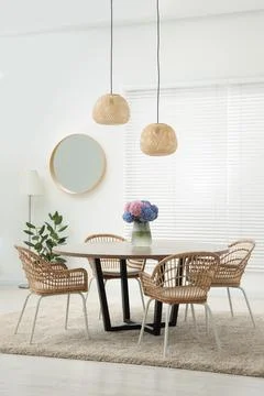 Table, chairs and vase of hydrangea flowers in dining room. Stylish interior Stock Photos