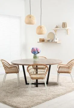 Table, chairs and vase of hydrangea flowers in dining room. Stylish interior Stock Photos