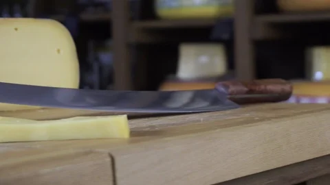 On the table is cheese and a knife for cheese. Production of natural cheese on Video stock 89005681