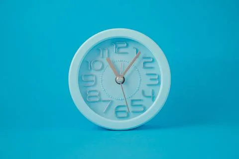 Table clock in the middle of the image isolated on blue background Illustration