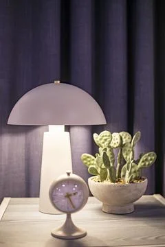 Table clock on a nightstand with a flower and a light bulb. Time changer Stock Photos