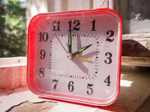 Table clock on windowsill of old summer house Stock Photos