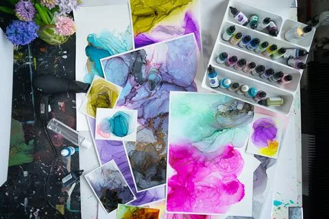 Table clutter in a creative studio. Alcohol Ink Painting. Above shot Stock Photos