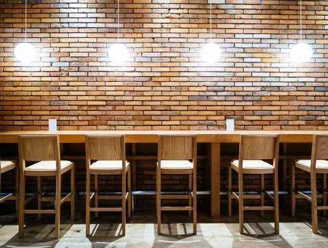 Table counter Bar Seats stool and Lights with Brick wall background Stock Photos