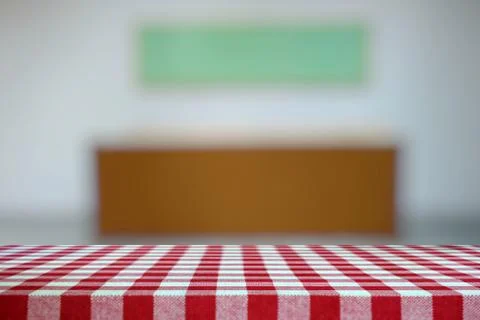 Table Covered with Red Checkered Tablecloth and Blurred Gallery Background. Stock Photos