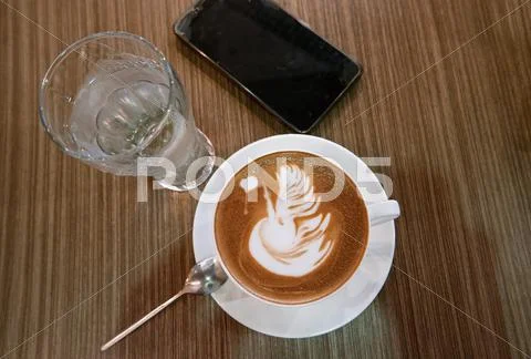 Table with cup of coffee, glass of water and smartphone top view Stock Photos
