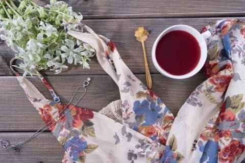 On the table is a cup of coffee, next to a women's dress Stock Photos