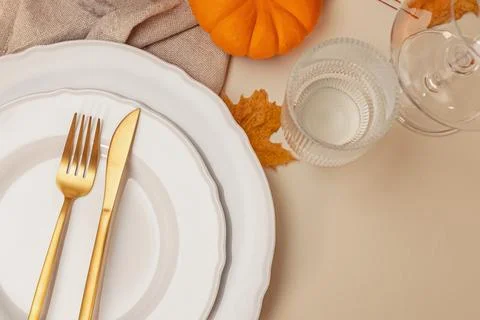 Table decorated for autumn dinner with white plates and golden cutlery, top.. Stock Photos