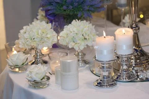 Table decorated with candles, hydrangeas and white roses Stock Photos