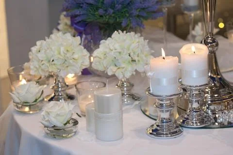 Table decorated with candles, hydrangeas and white roses Foto stock