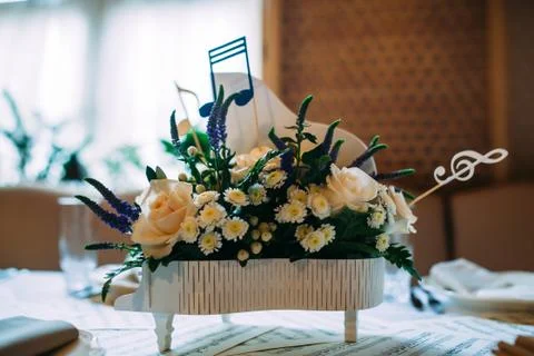 Table decorated with notes and flowers in a small piano Stock Photos
