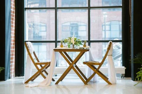 Table decorated with plates, pineapples, candles and flowers, green and white Stock Photos