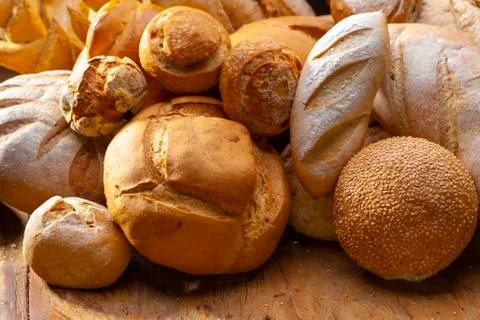 Table decorated with various artisan breads produced with studio light. Stock Photos