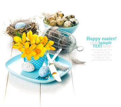 Table decoration with easter eggs nest on plate, on white wooden background Stock Photos