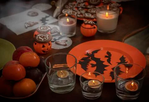Table with decorations, candles and sweets for Halloween. Stock Photos