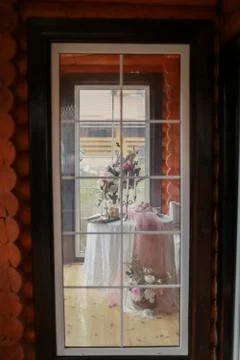 Table with decorations in the room view through the closed glass door Stock Photos