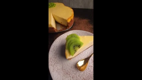On the table is a delicious cheesecake with cottage cheese, decorated with kiwi. Stock Footage 300596953
