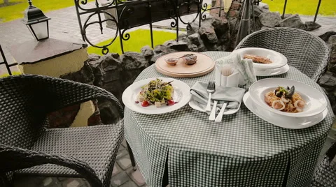 Table with dishes in a cafe on the street Stock Footage 63232061
