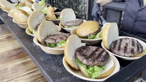 On table during buffet lunch on plates lie hamburgers. Stock Footage 245339836