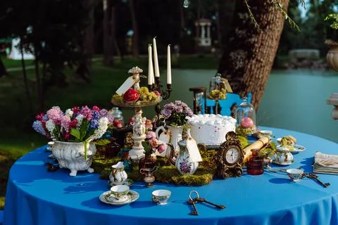 The table is elegantly decorated for a tea party in the style of Alice in Stock Photos