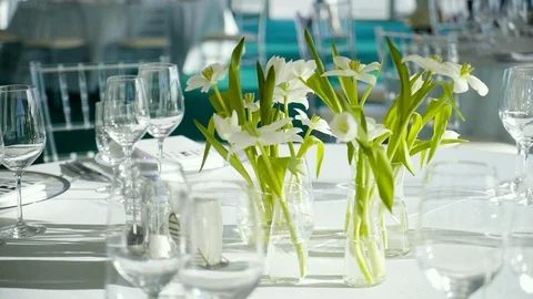 Table with empty dishes and glasses at a banquet with white flowers Stock Footage 124384239