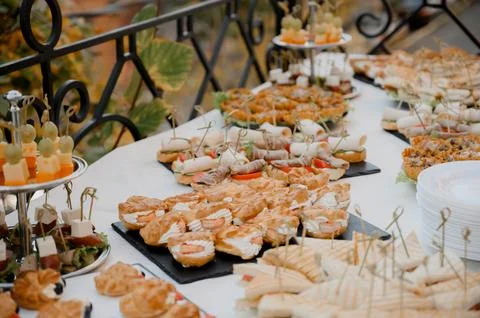 A table with exquisite snacks, cakes and sandwiches for a buffet on the terra Stock Photos