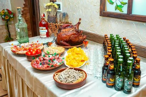 A table is filled with an array of appetizers, drinks, and a perfectly roaste Fotos de archivo