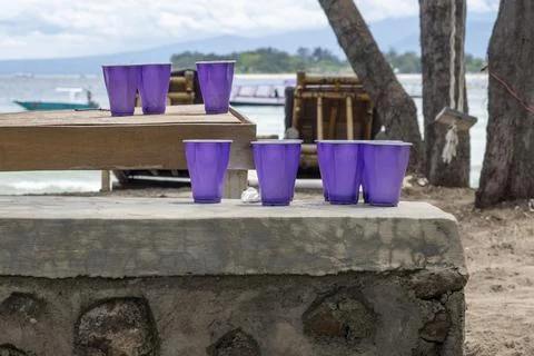 Table with five purple plastic cups on it 스톡 사진