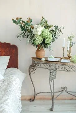 Table With Flowers Beside Bed Stock Photos